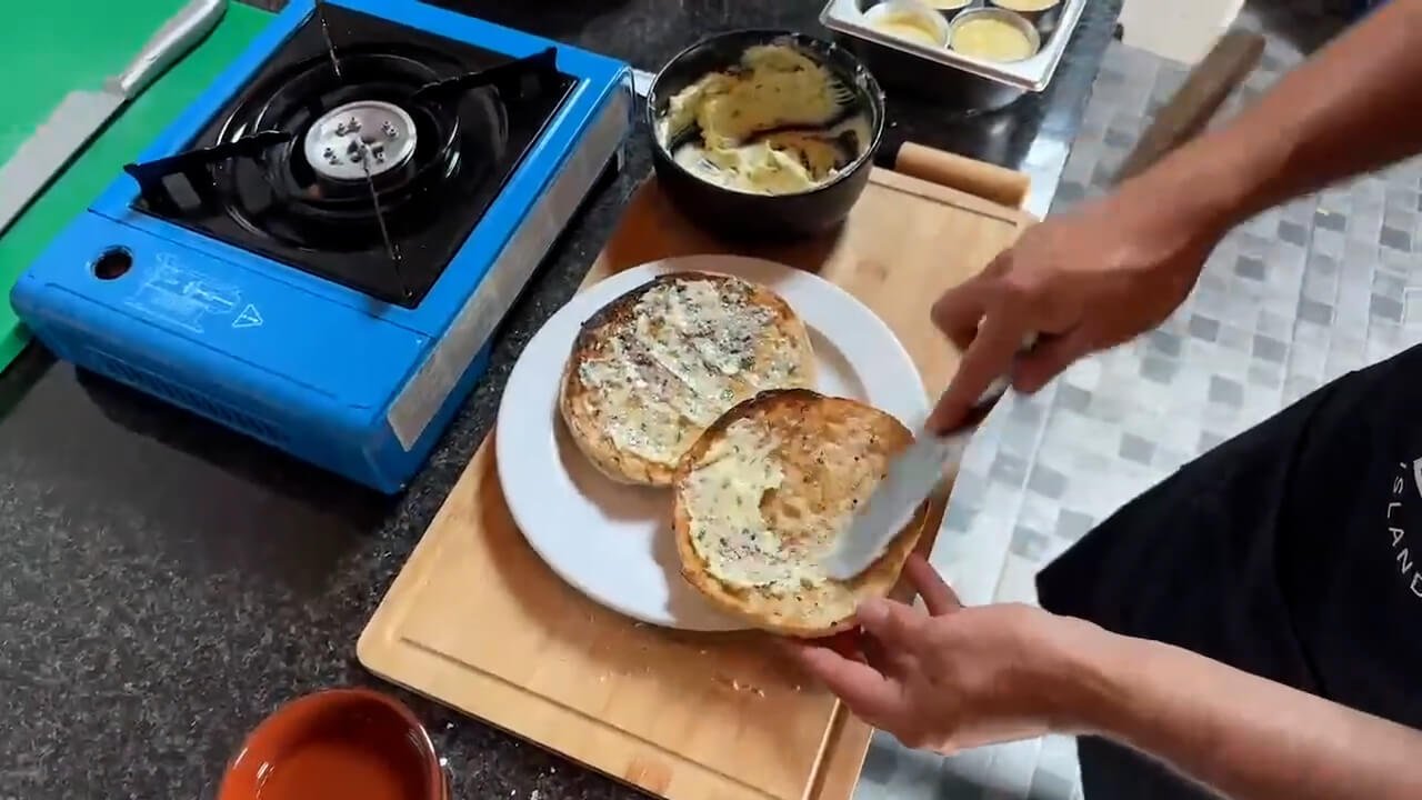 Preparing garlic butter for traditional Madeira bolo do caco during the Santo da Serra cooking livestream