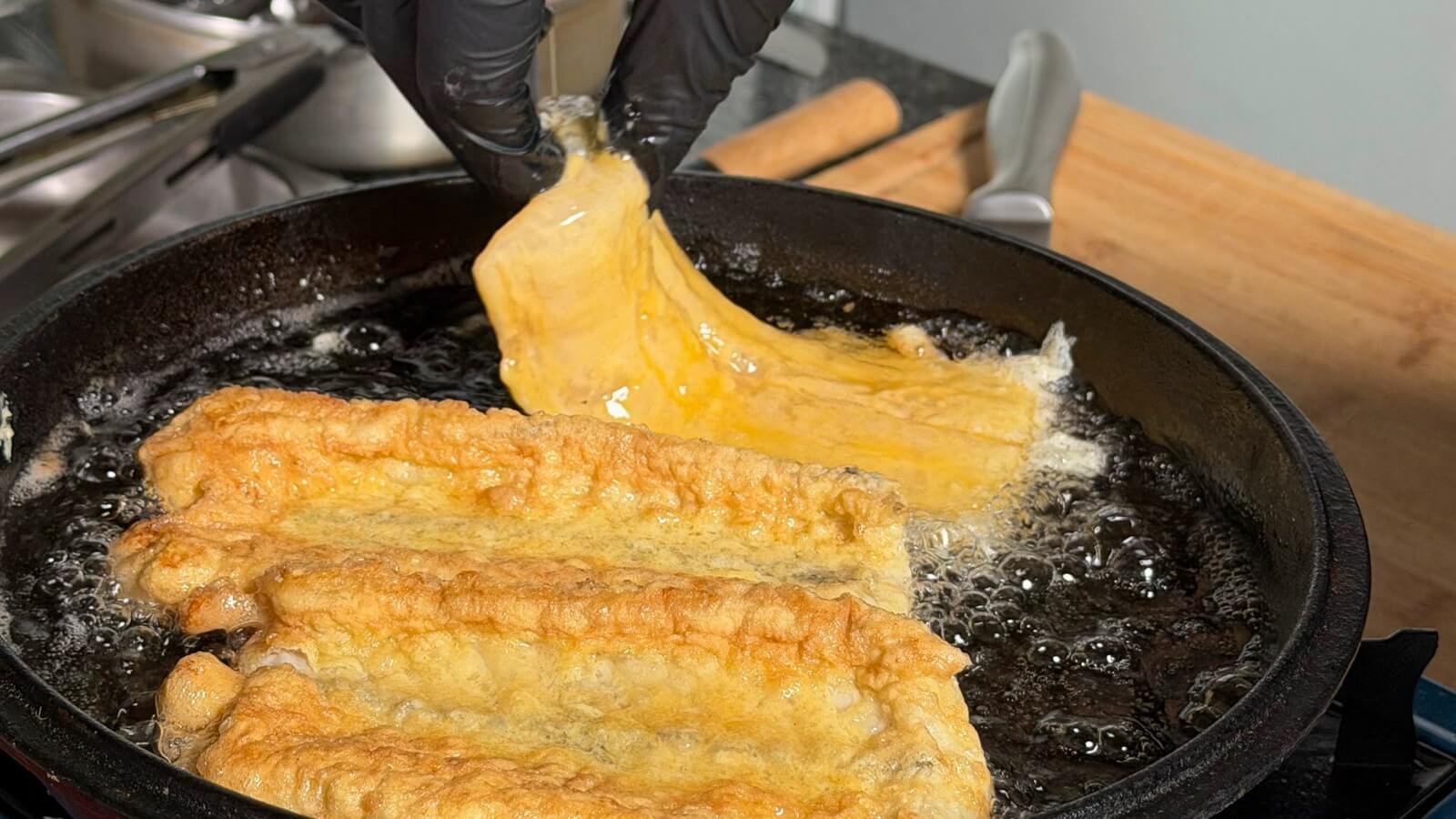 Traditional black scabbardfish frying during a Madeira cooking experience in Santo da Serra