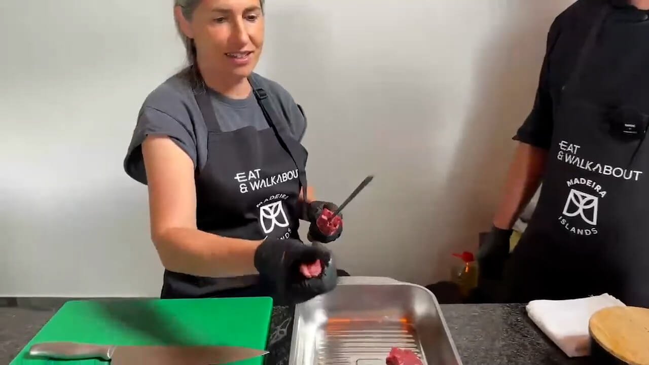 Preparing traditional Madeira beef espetada during a cooking experience in Santo da Serra