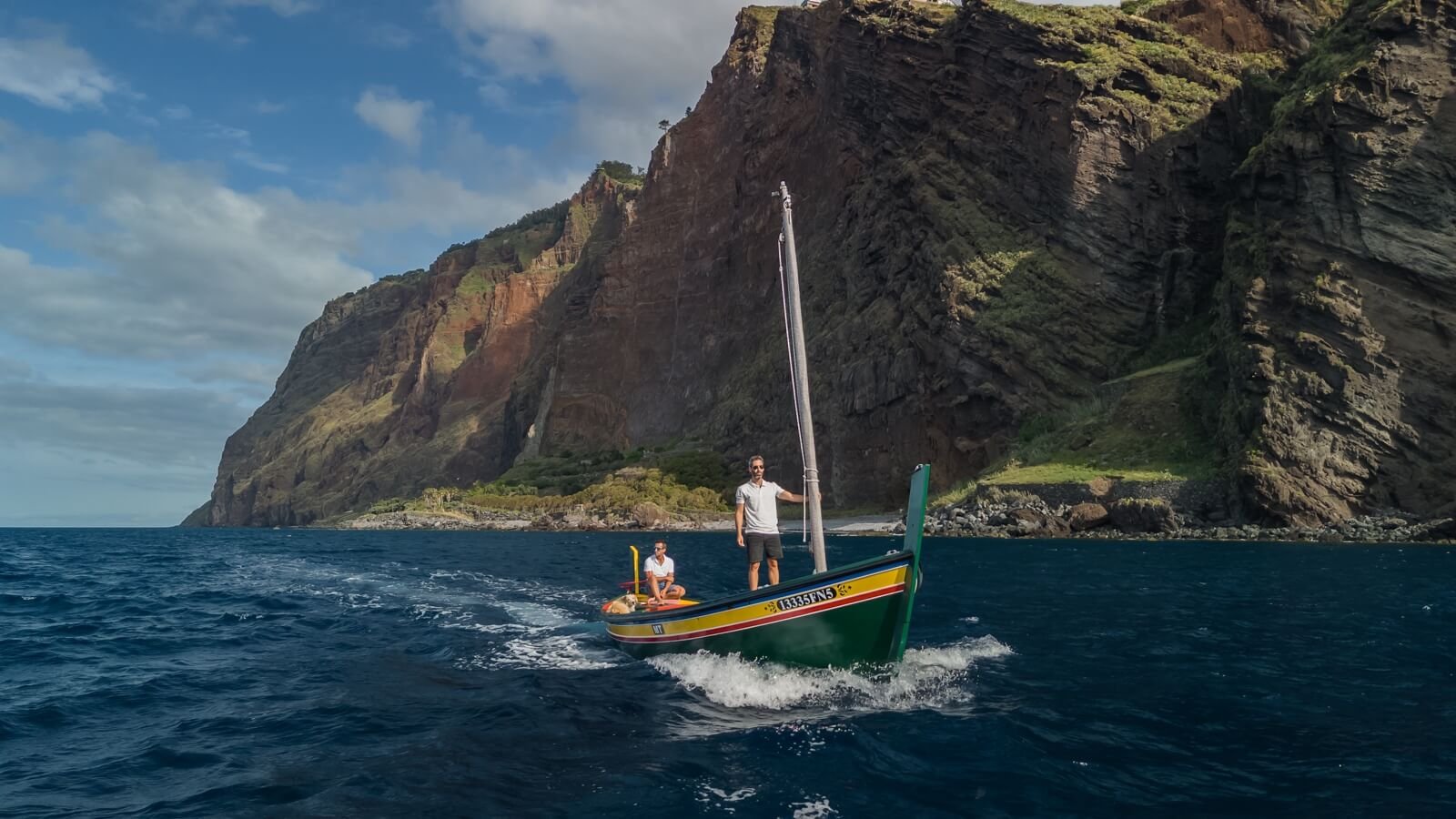 Traditional Xavelha boat sailing along Madeira coast near Cabo Girao