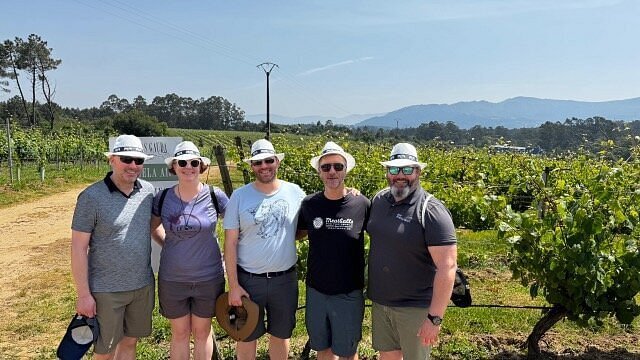 Small group walking through a sunny vineyard during a wine country tour with Eat & Walkabout.
